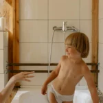 Tout-petit assis sur son pot dans la salle de bain en souriant