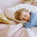 Petit enfant endormi pour sa sieste sur un lit douillet