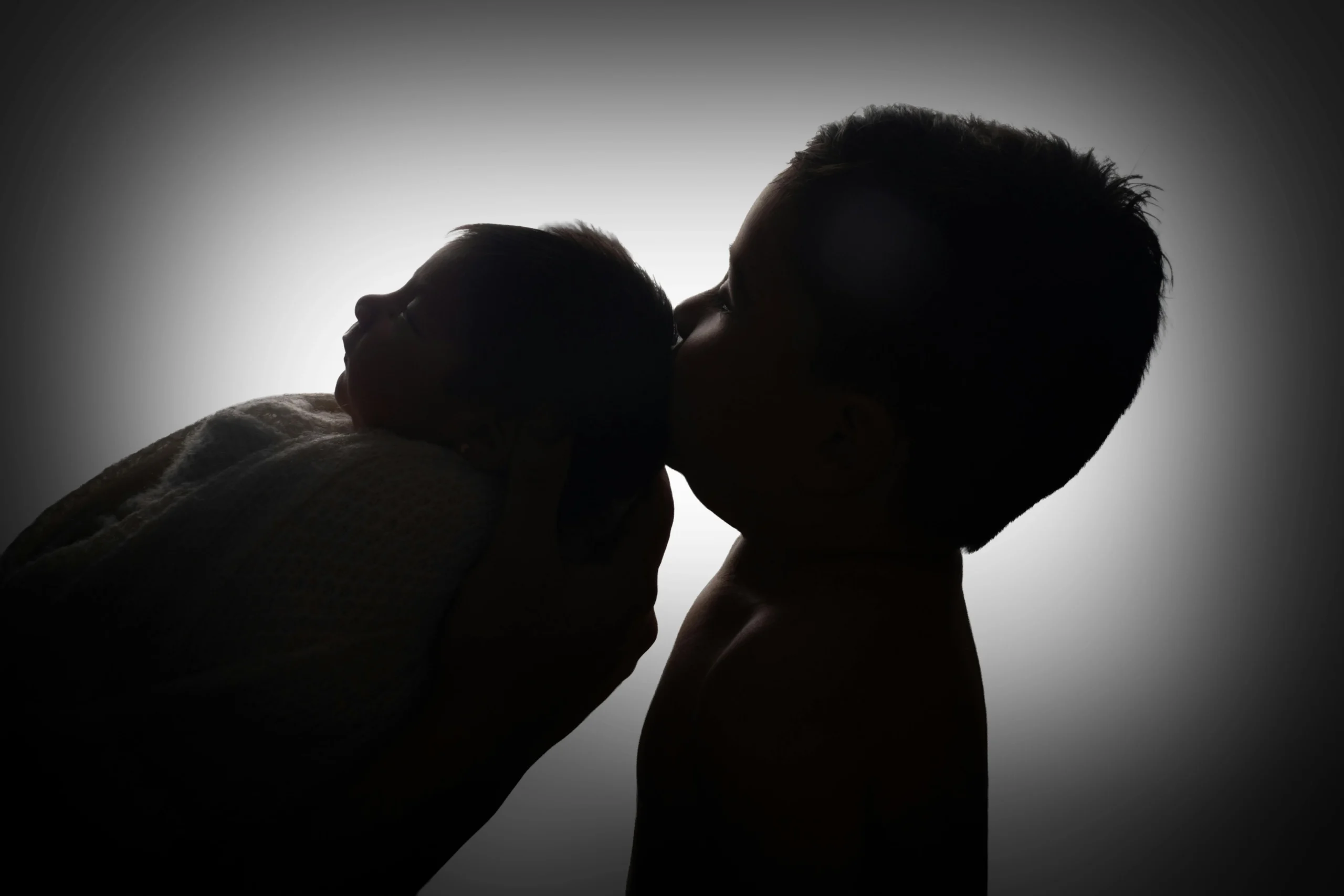 grand frère qui rencontre tendrement son nouveau-né dans le berceau