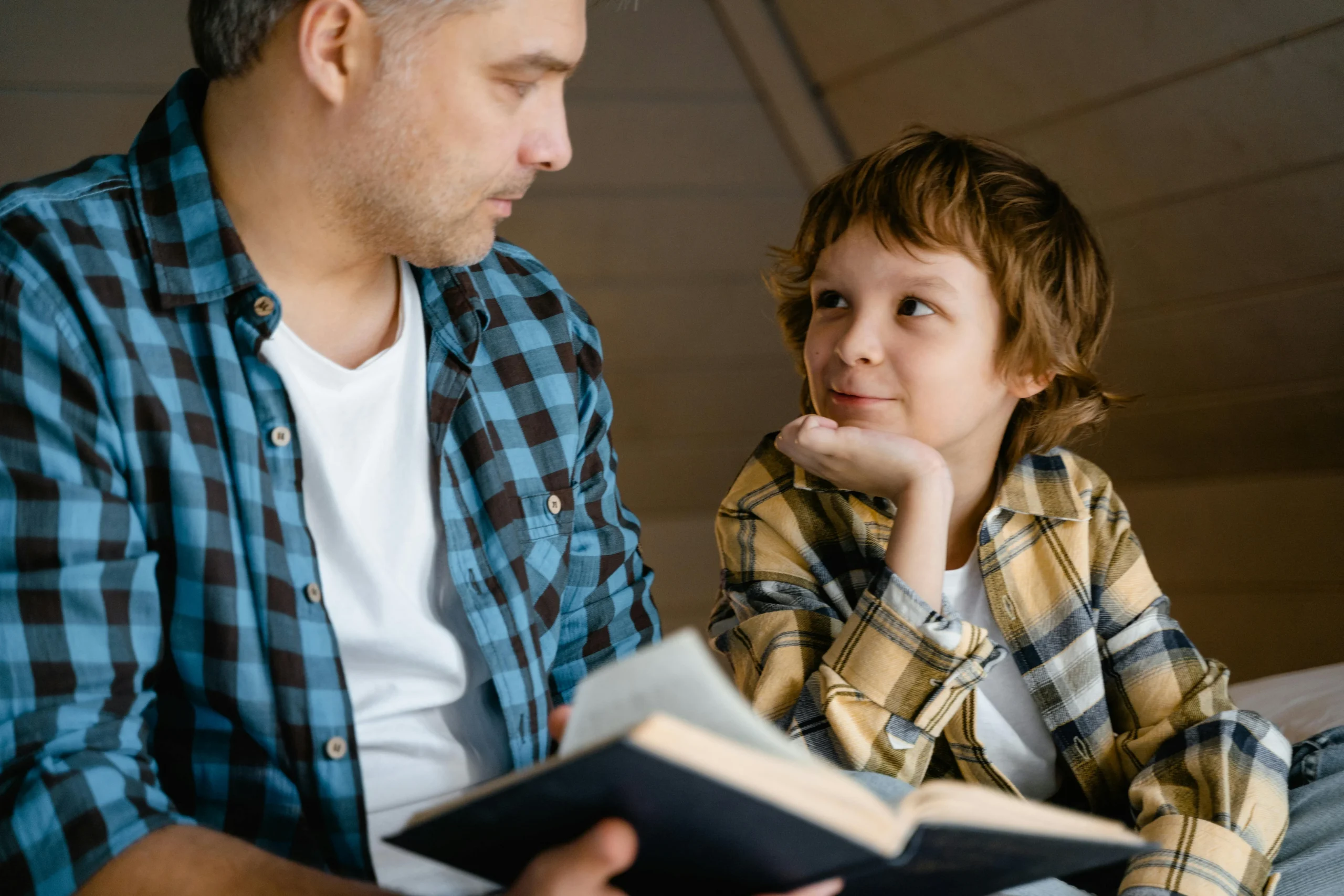 petit enfant absorbé qui écoute une histoire familière le sourire aux lèvres