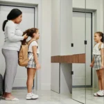 Petit enfant avec son cartable devant l'école maternelle le matin