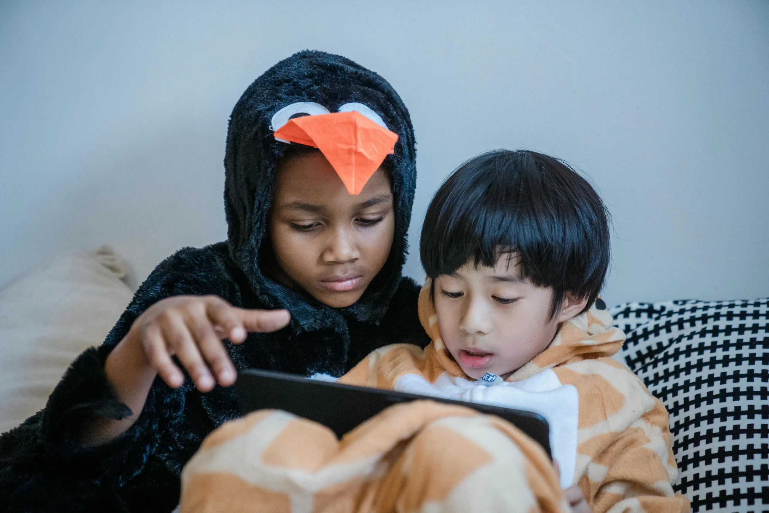 jeune enfant qui regarde une tablette dans le salon