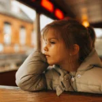 enfant qui regarde le paysage par la fenêtre du train